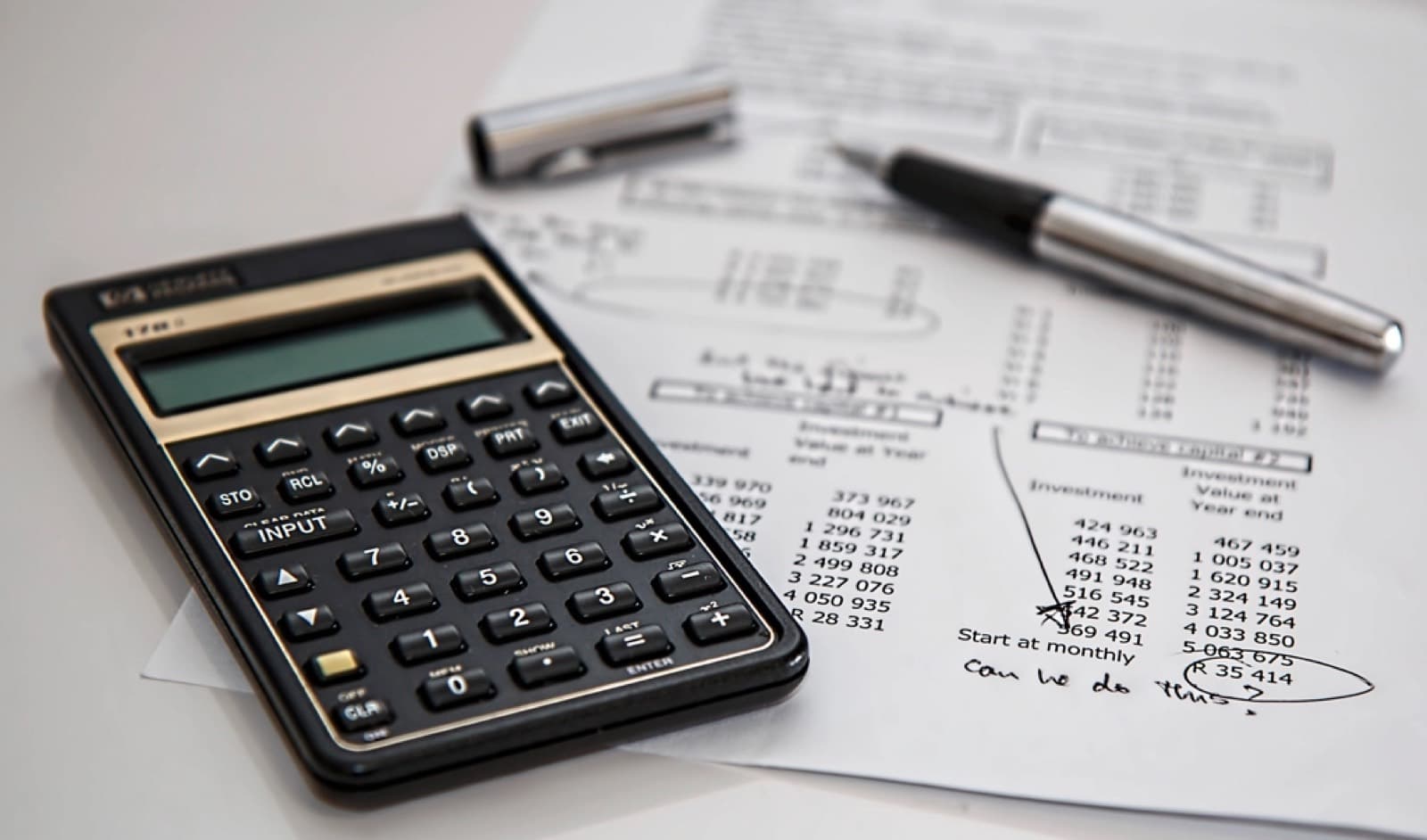 A financial calculator resting on a printed sheet of figures