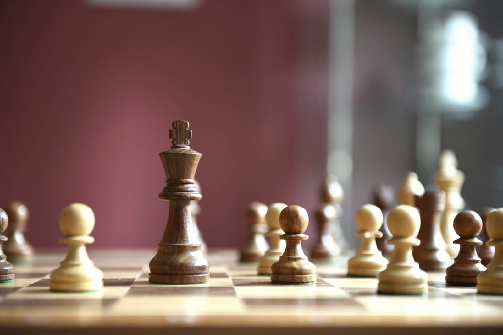 A chess board mid-game, the king in focus and pawns ahead of it